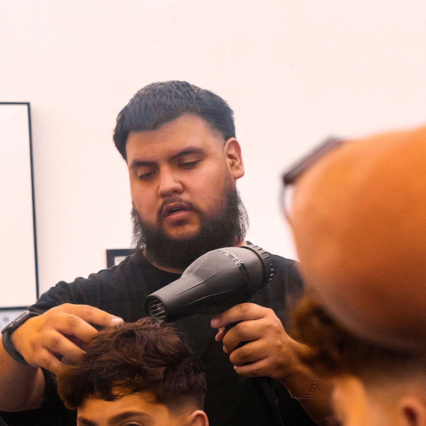 A Kongo barber cutting a client at the chair