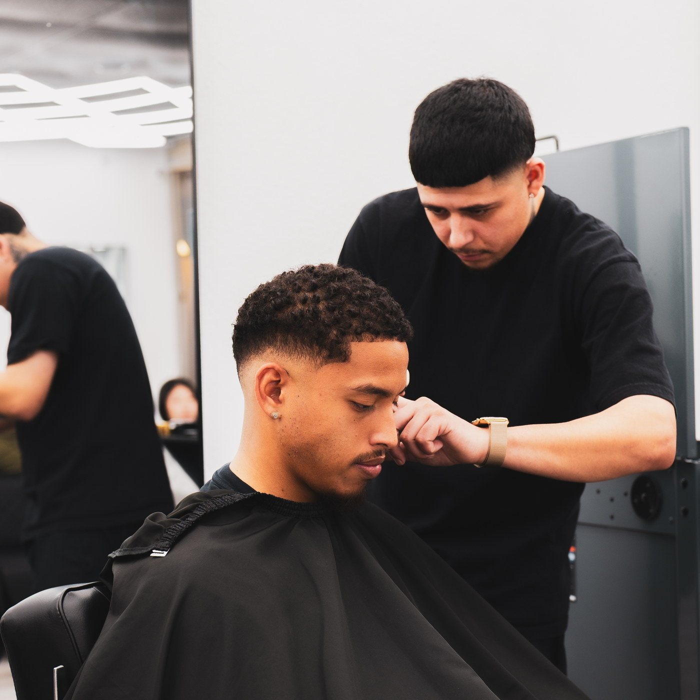 A Kongo barber lining up a fade
